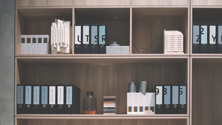 Paperwork organized into binders and stored neatly on shelves.