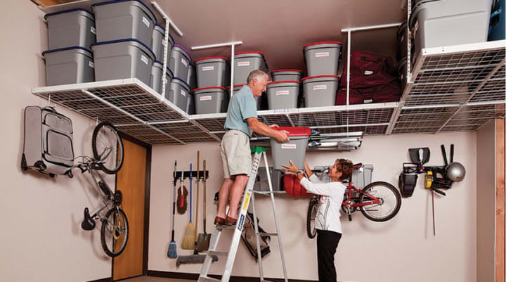decluttering garage tip - couple using overhead garage storage