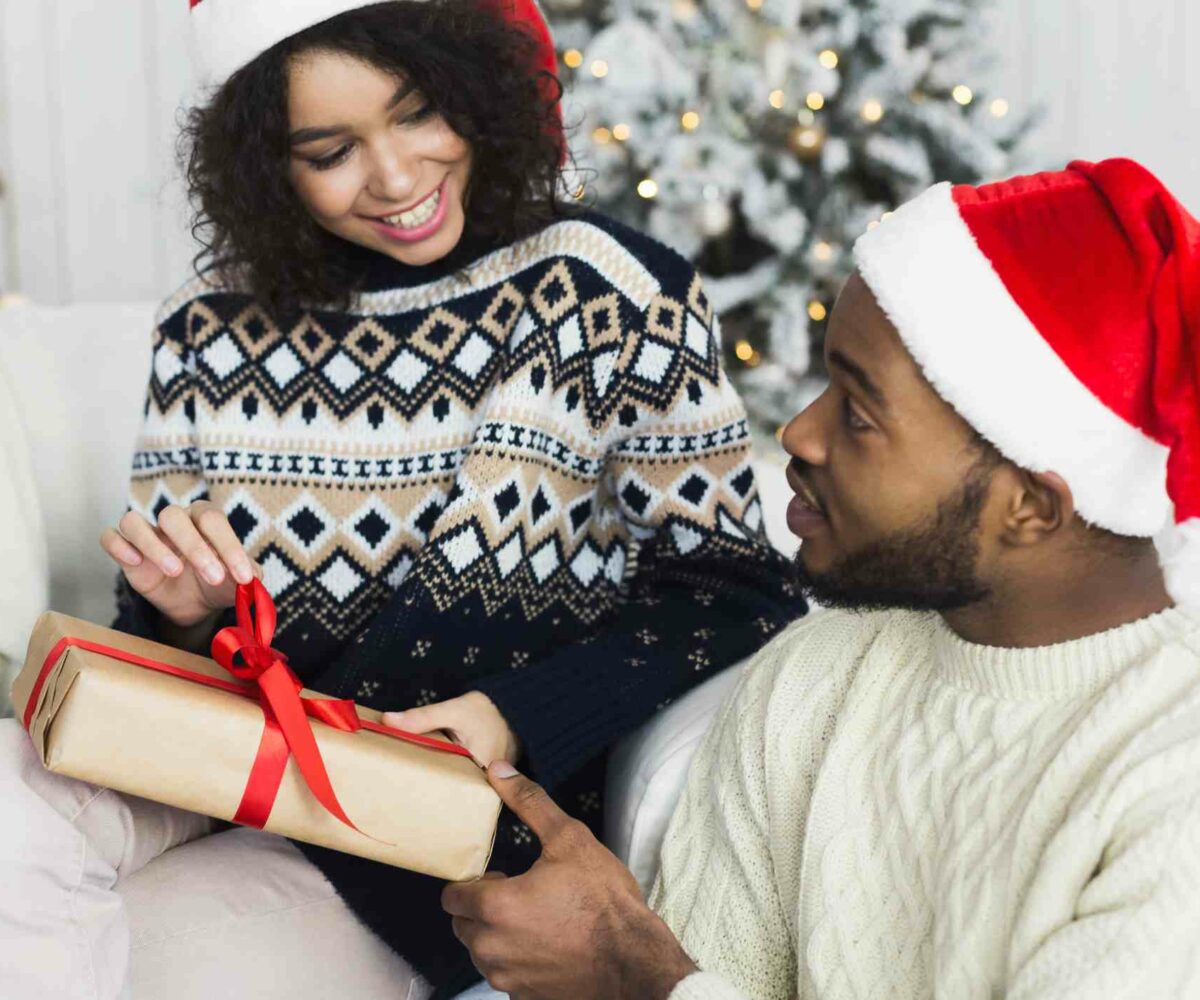 A man and woman exchanging gifts on Christmas morning.