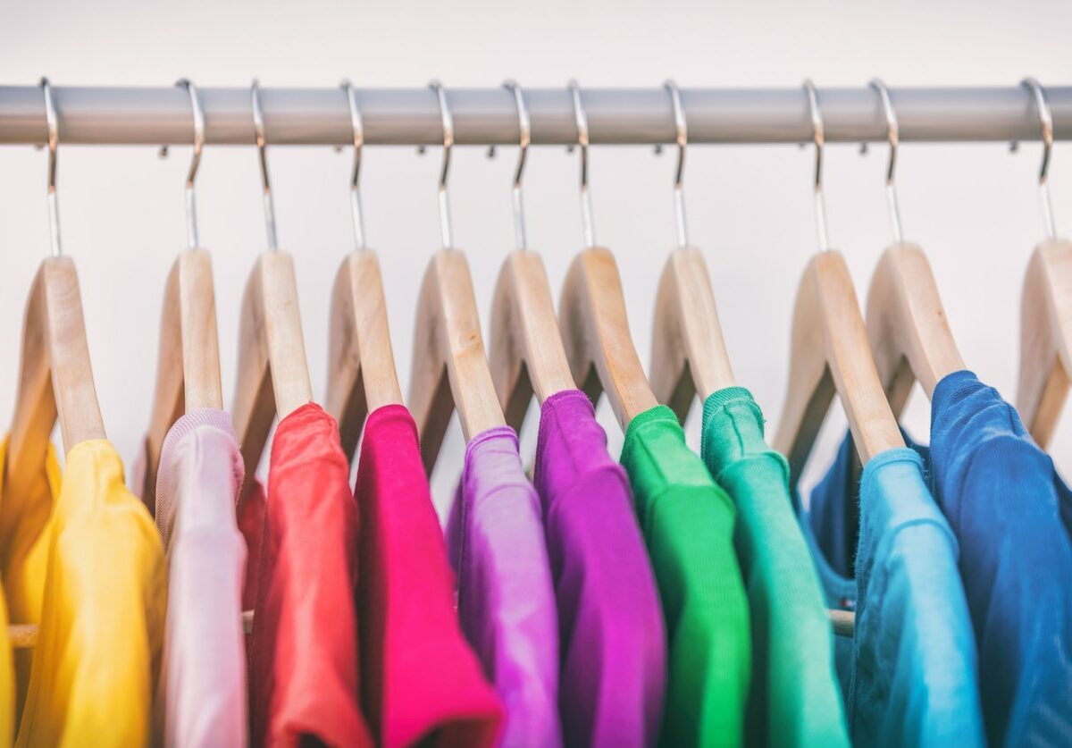 Various shirts in assorted summer colours on a clothing rack.