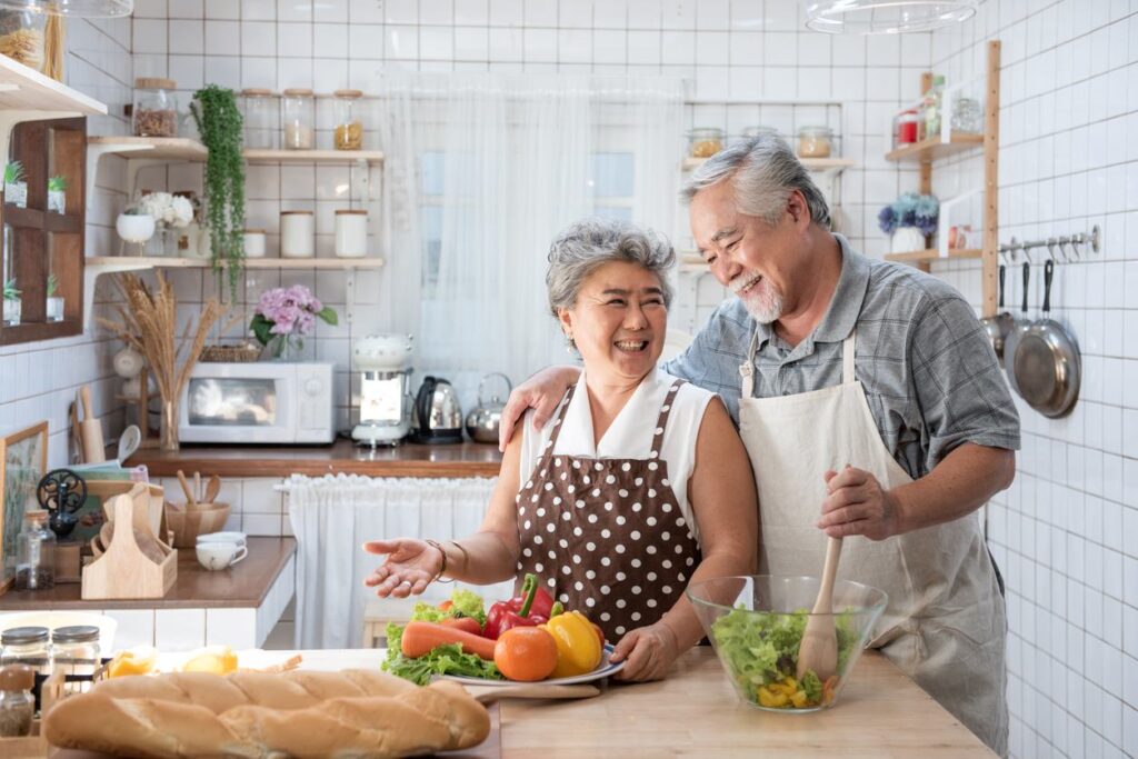 An empty-nester couple cooks together in their newly downsized home.