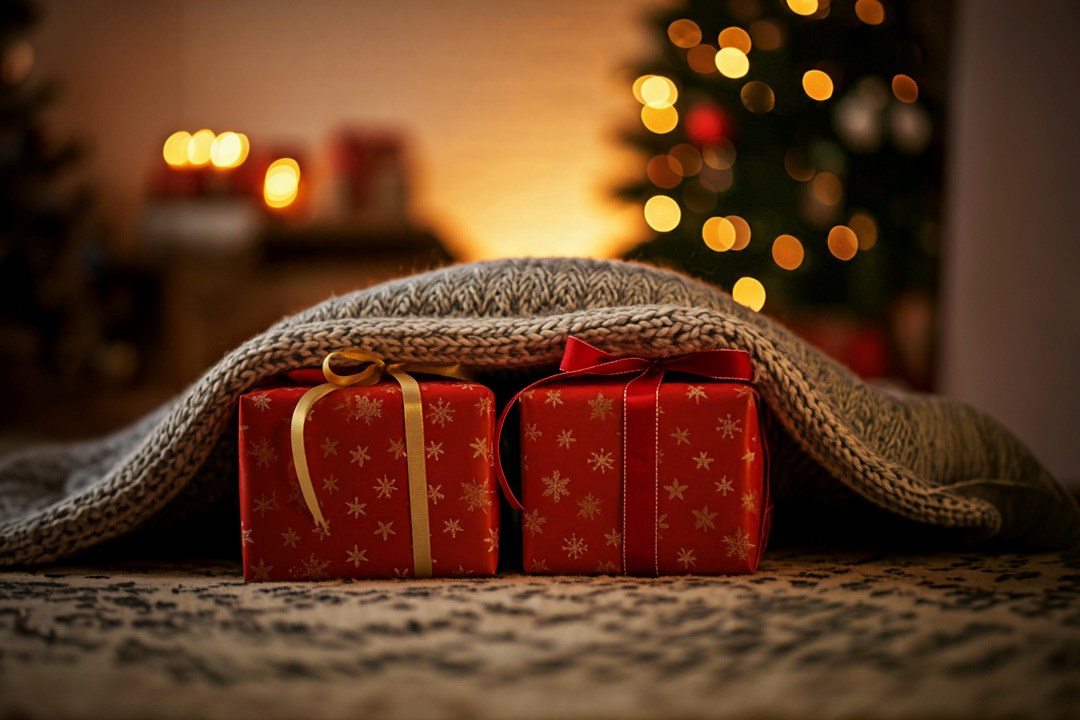 Two presents partly covered up by a woven blanket.