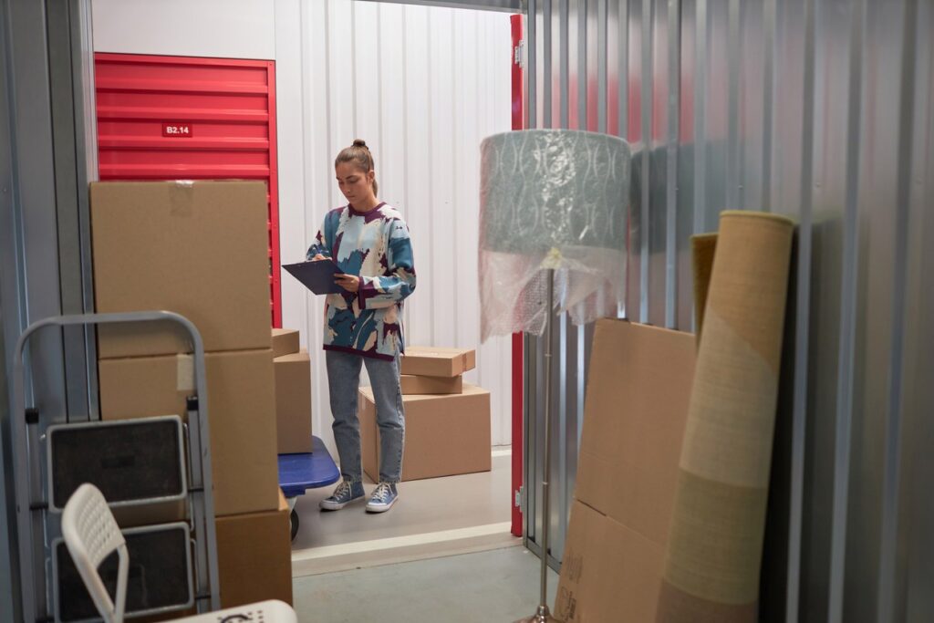 A woman carefully packs her temporary storage unit with boxes and furniture. 